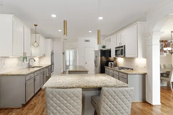 a kitchen with stainless steel appliances granite countertop a sink stove and refrigerator