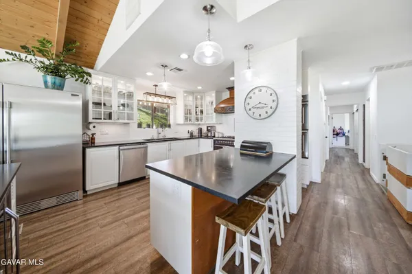 a kitchen with kitchen island a wooden floor and white appliances