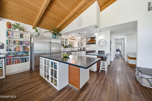 a kitchen with stainless steel appliances granite countertop a lot of counter space and wooden floors