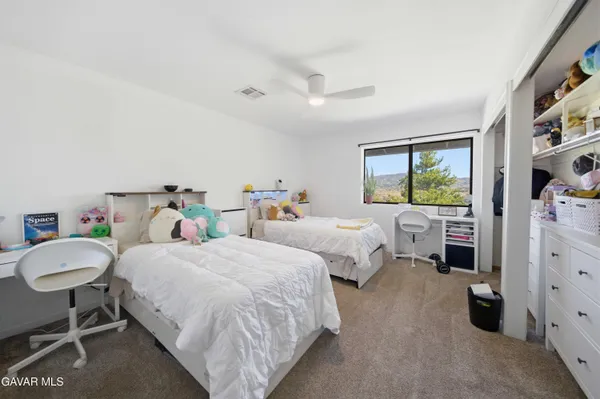 a bed room with two bed and a chair