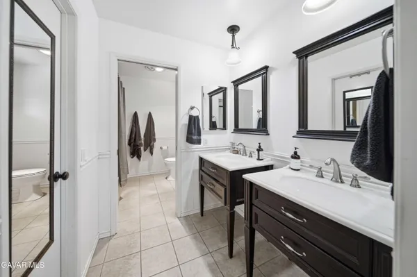 a en suite bathroom with a double vanity sink and a mirror