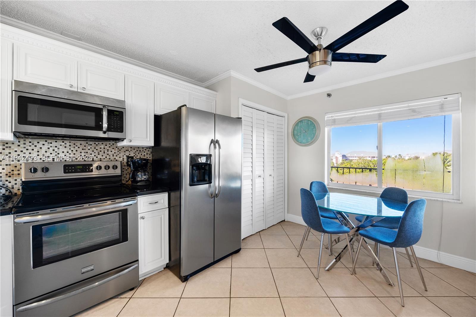 275 Palm Avenue, Unit A407 Jupiter, FL 33477 - Photo 11 of 29 a kitchen with stainless steel appliances kitchen island granite countertop a stove top oven a sink a dining table and chairs