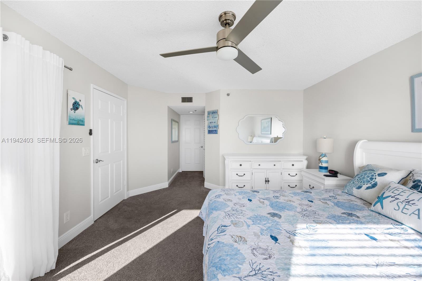 275 Palm Avenue, Unit A407 Jupiter, FL 33477 - Photo 15 of 29 a bedroom with a large bed and a chandelier