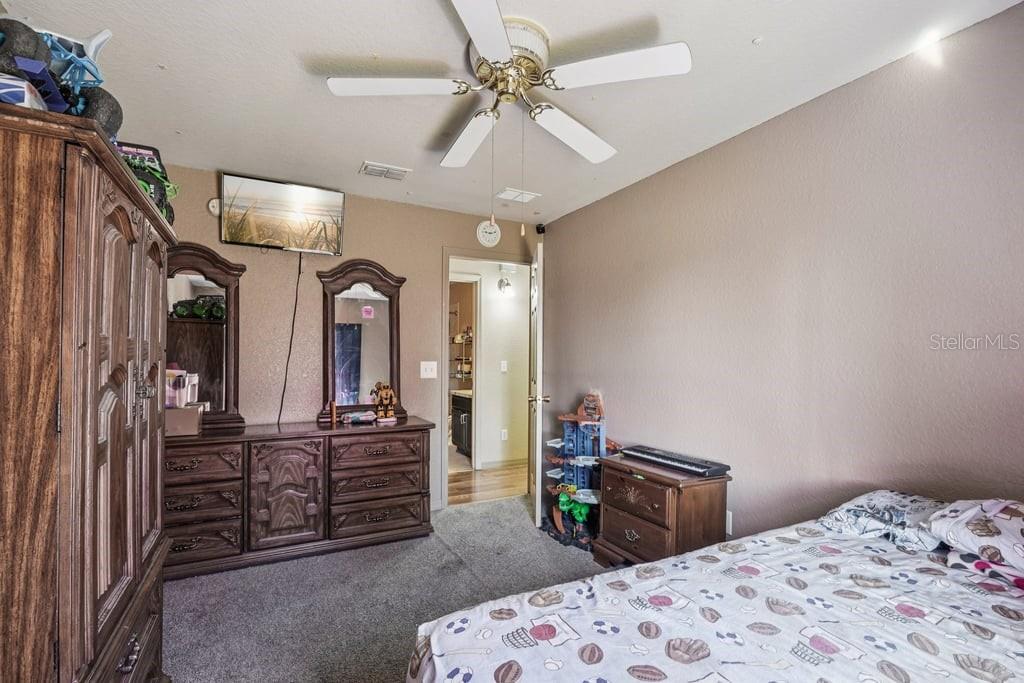 133 Walnut Road Ocala, FL 34480 - Photo 18 of 31 a bedroom with a bed dresser and a chandelier