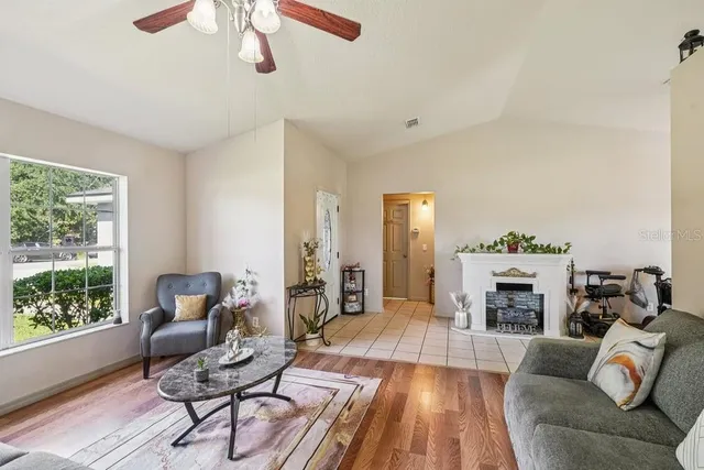 a kitchen with stainless steel appliances a refrigerator a stove a sink dishwasher a dining table and chairs with wooden floor