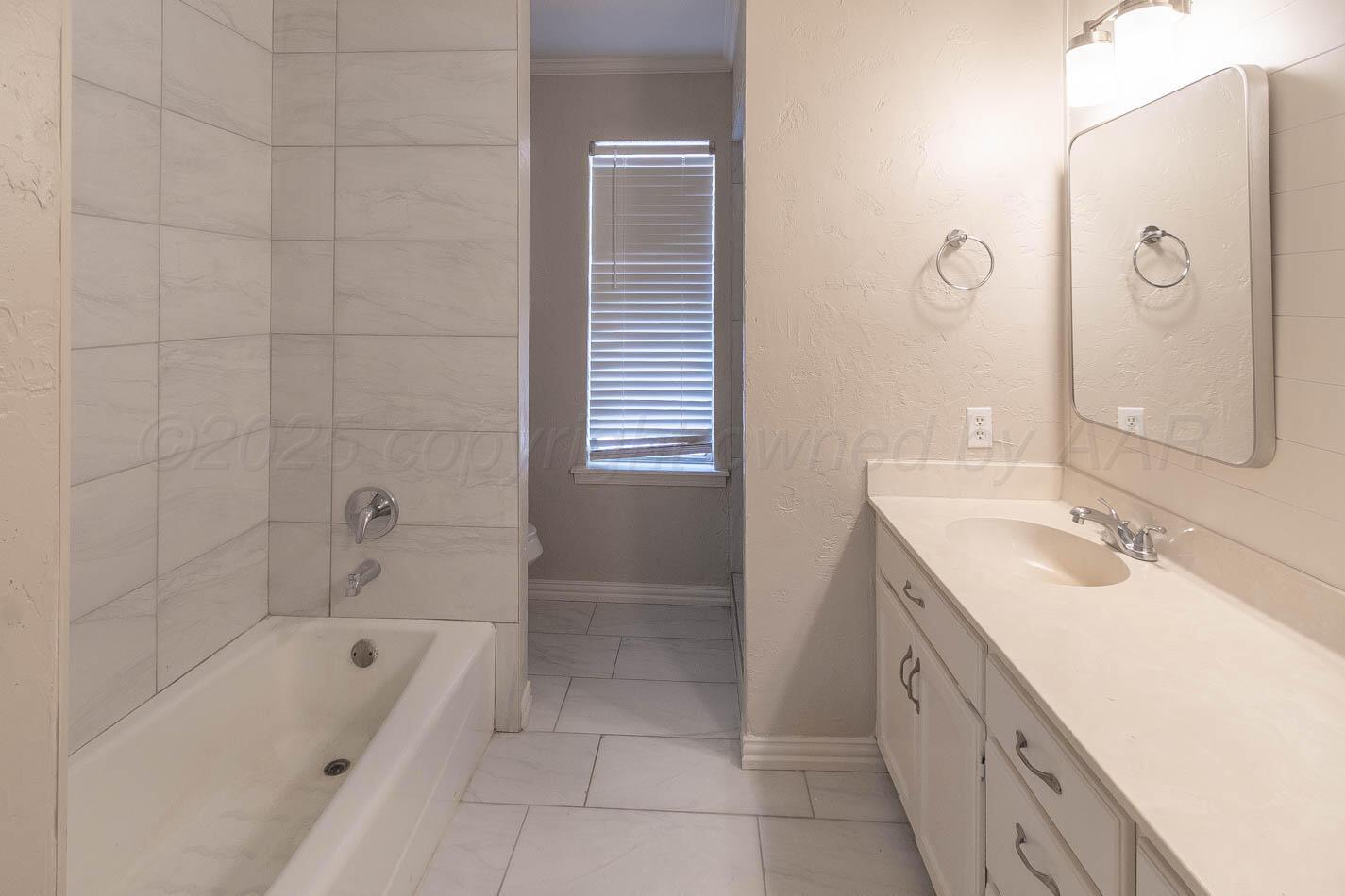 7209 Dukes Place Amarillo, TX 79109 - Photo 14 of 20 a bathroom with a tub sink and mirror
