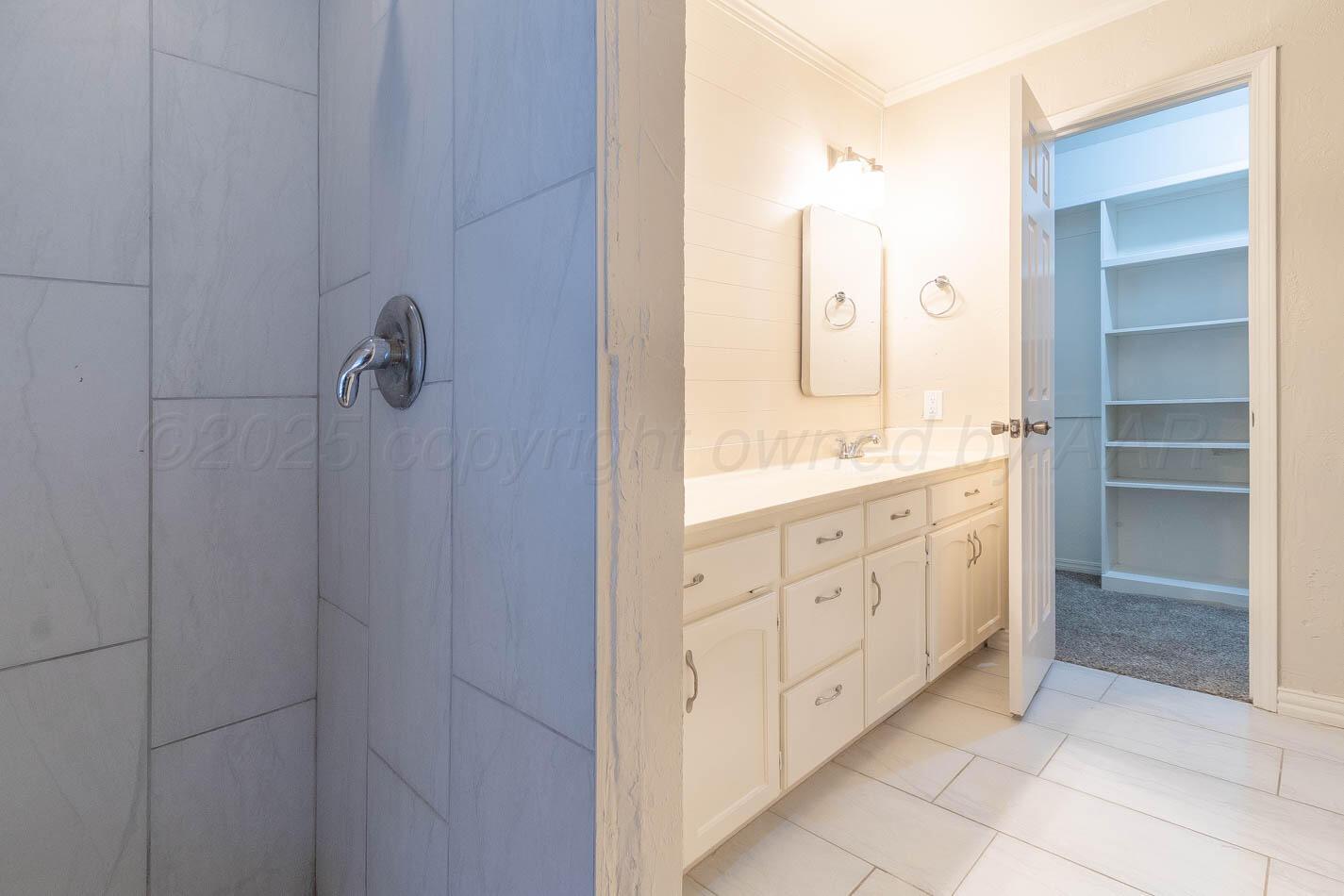 7209 Dukes Place Amarillo, TX 79109 - Photo 15 of 20 a spacious bathroom with a granite countertop sink a mirror and a