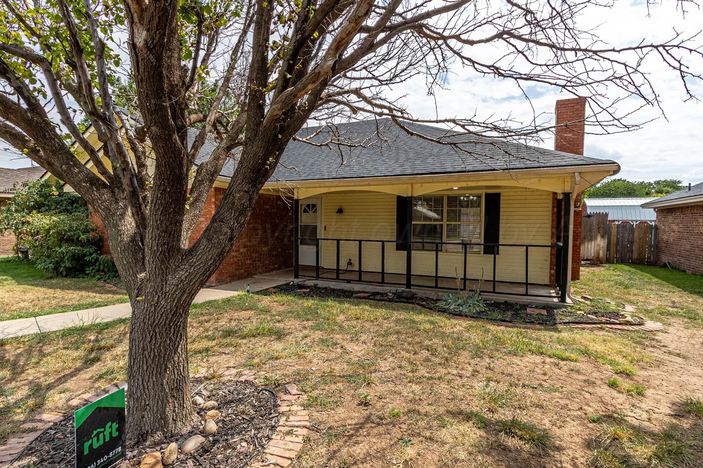 7209 Dukes Place Amarillo, TX 79109 - Photo 2 of 20 a view of a house with large tree and wooden fence