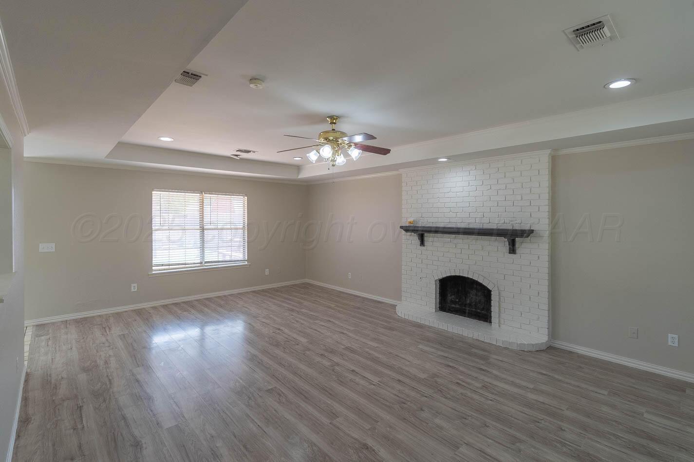 7209 Dukes Place Amarillo, TX 79109 - Photo 3 of 20 wooden floor in an empty room with a fireplace