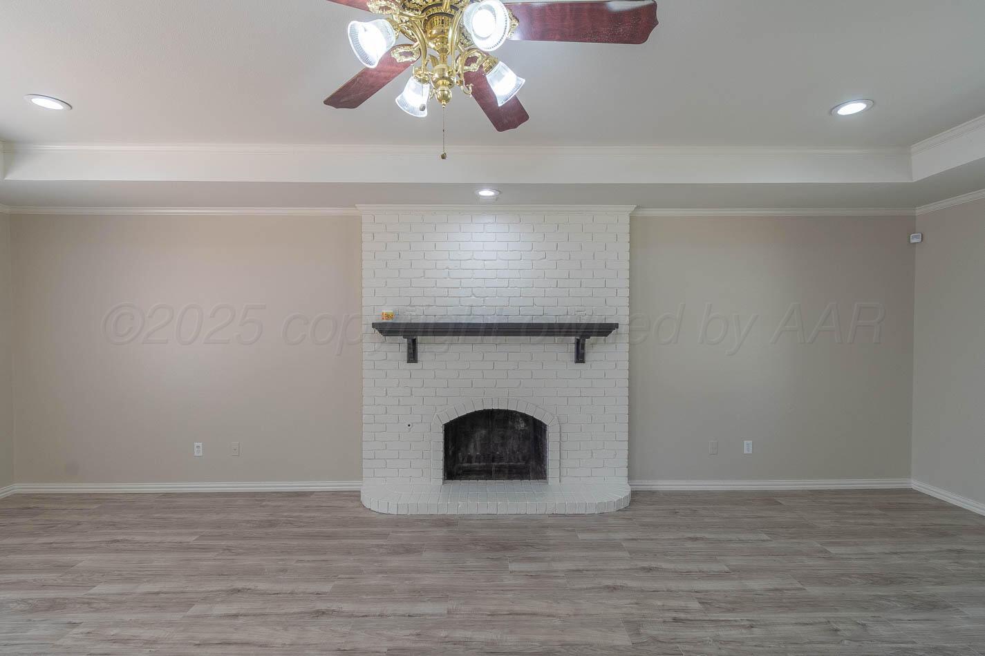 7209 Dukes Place Amarillo, TX 79109 - Photo 5 of 20 a view of an empty room with a fireplace and a chandelier fan