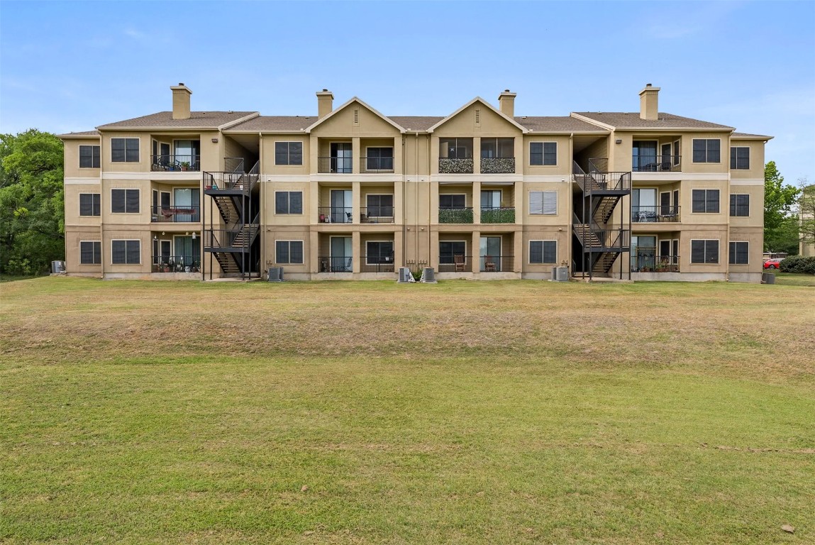 3401 West Parmer Lane, Unit 725 Austin, TX 78727 - Photo 2 of 16 a front view of a building with a garden