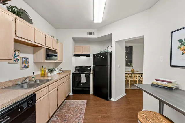 a kitchen with stainless steel appliances kitchen island granite countertop a refrigerator and a sink