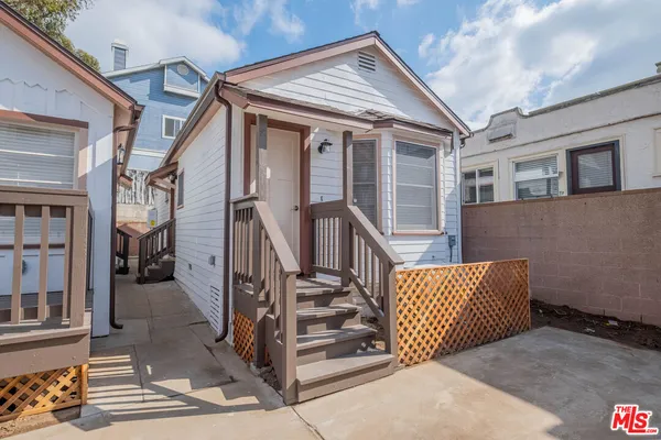 a view of front door deck with furniture and staircase