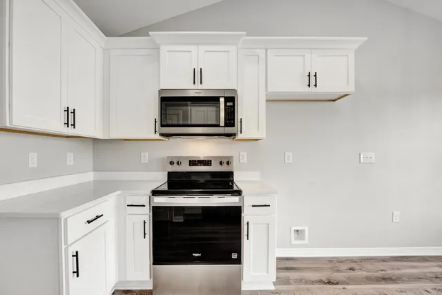 a kitchen with white cabinets and stainless steel appliances