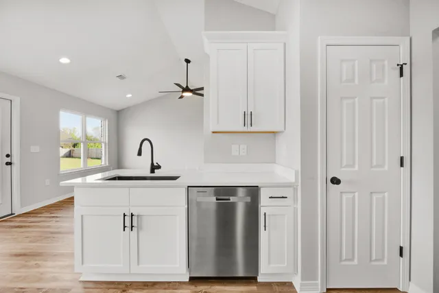 a kitchen with white cabinets and sink