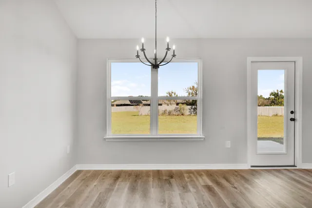 a view of a room with wooden floor and a chandelier