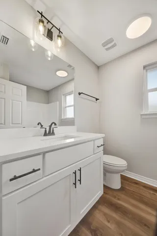 a bathroom with a toilet sink and mirror