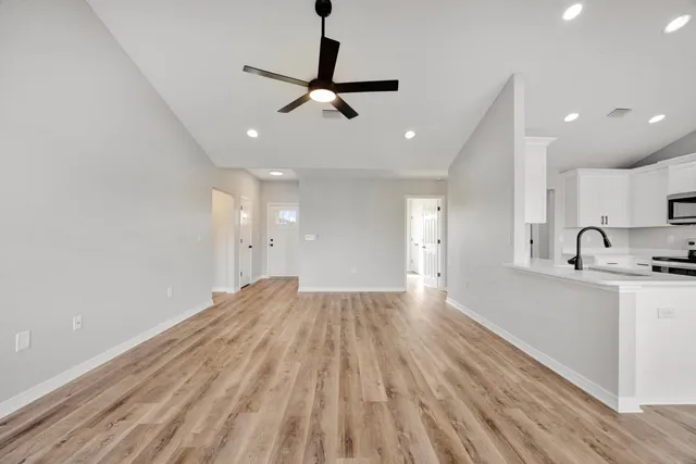 a view of empty room with wooden floor and window