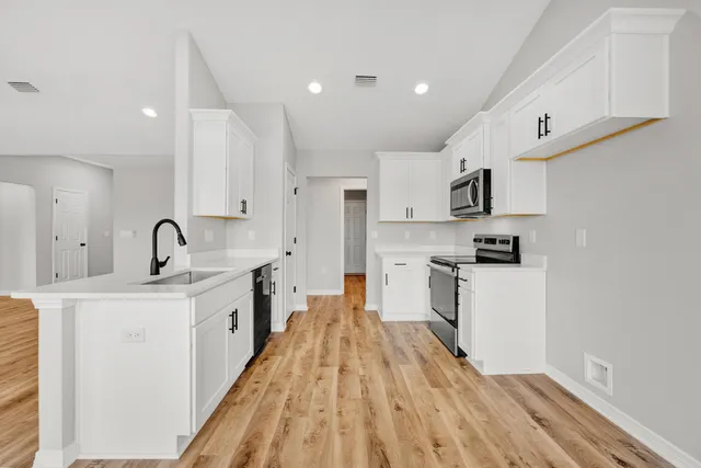 a kitchen with white cabinets stainless steel appliances and sink