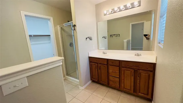 a bathroom with a double vanity sink a mirror and a shower