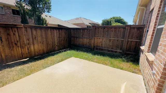 a view of backyard with wooden fence and trees