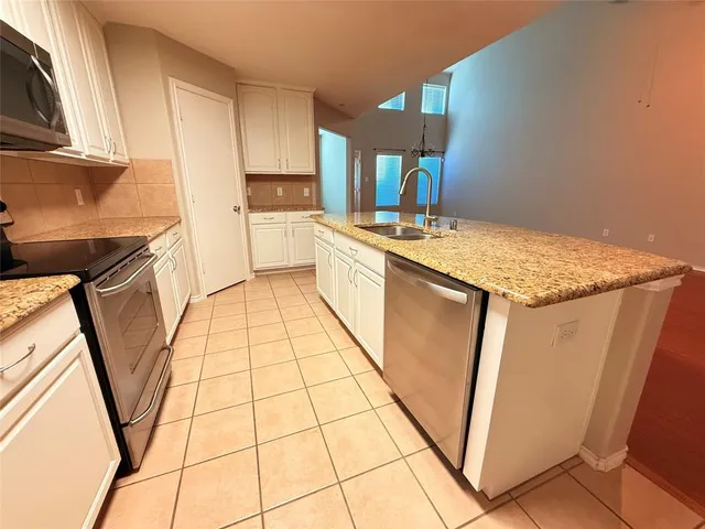 a kitchen with a sink a refrigerator and cabinets