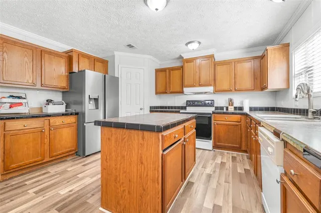 a kitchen with stainless steel appliances granite countertop a stove a sink dishwasher and a refrigerator