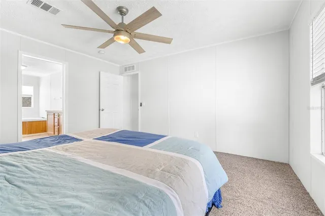 a bedroom with a bed and a chandelier fan