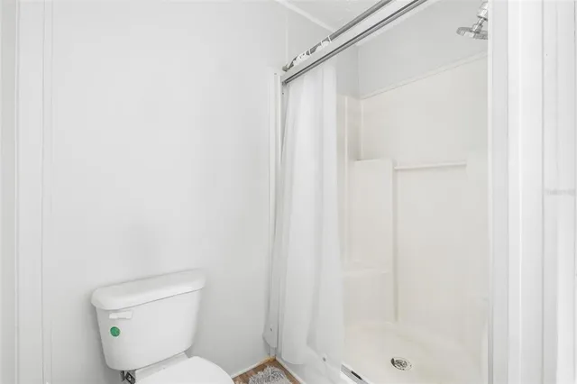 a white toilet sitting next to a shower