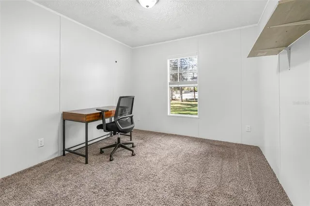 a view of a workspace with furniture and a window