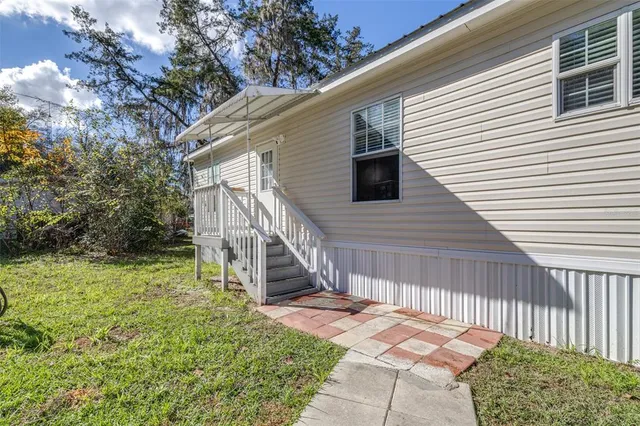 a view of backyard with deck and wooden stairs