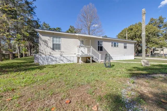 a view of a house with backyard and trees