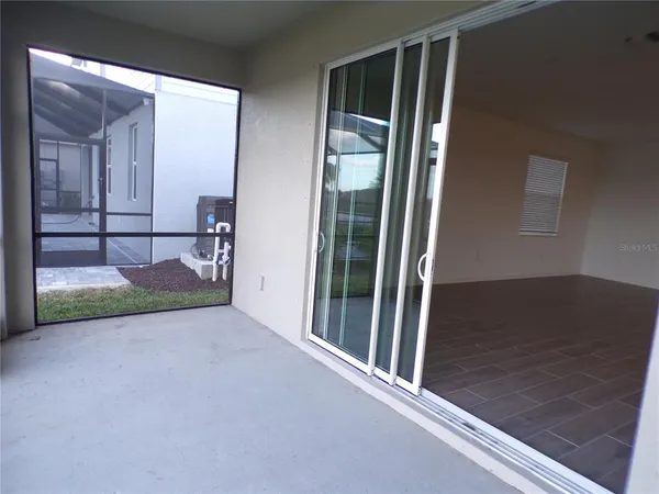 a view of a hallway with wooden floor and windows