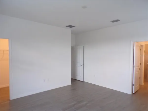 an empty room with wooden floor and a window