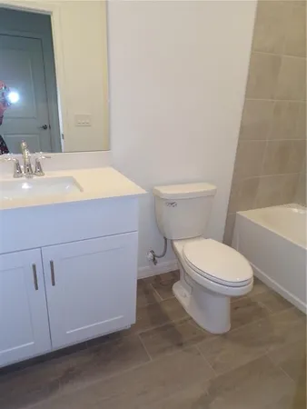 a white toilet sitting next to a bath tub