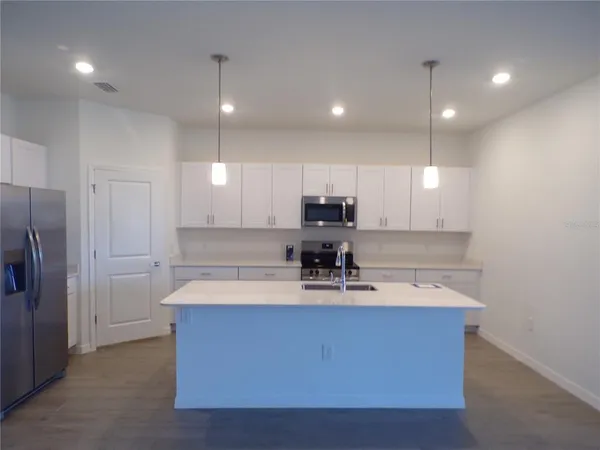 a view of kitchen with refrigerator sink and wooden floor