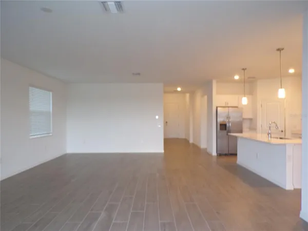 a view of a big room with wooden floor and windows