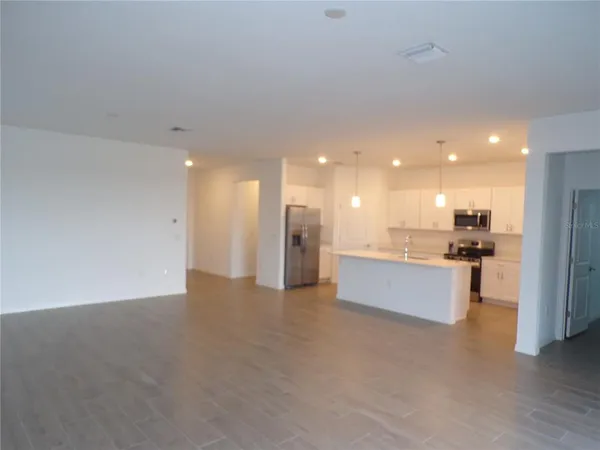 a view of a kitchen with kitchen island and stainless steel appliances