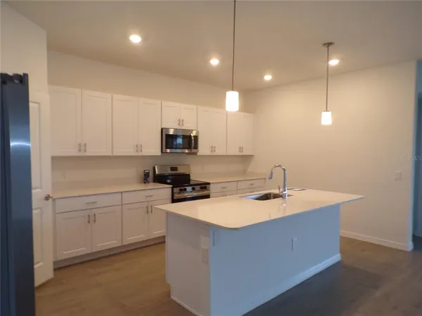 a kitchen with kitchen island sink stove and cabinets