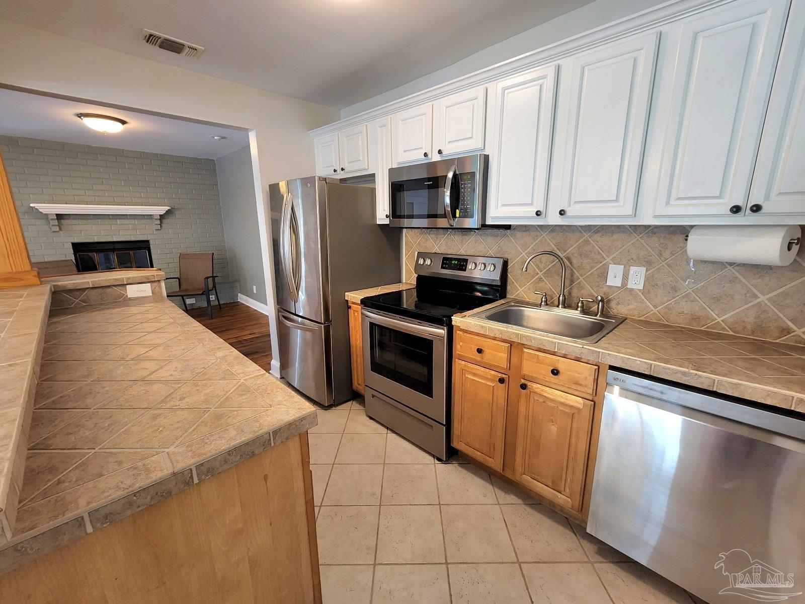 206 Berry Road Pensacola, FL 32507 - Photo 2 of 17 a kitchen with granite countertop a stove sink and microwave