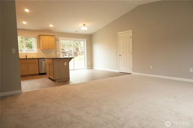 a kitchen with kitchen island a counter top space a sink stainless steel appliances and cabinets