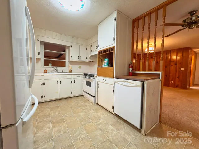 a kitchen with white cabinets and white appliances