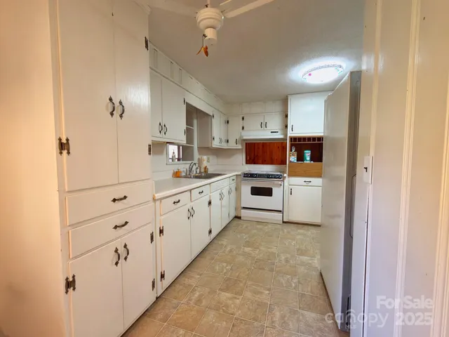 a large white kitchen with cabinets and stainless steel appliances