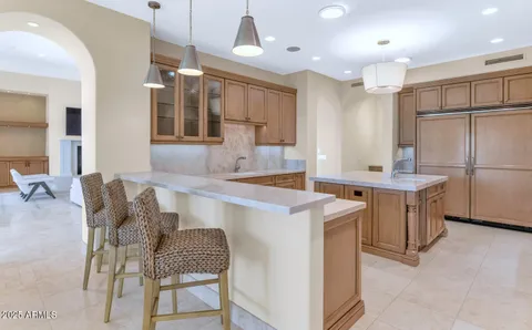 a kitchen with a refrigerator a sink and chairs