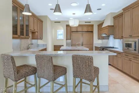 a kitchen with granite countertop a table chairs stove and sink