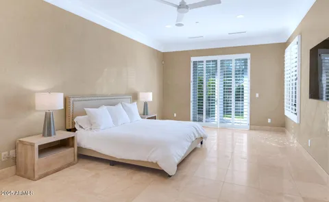 a bedroom with a large bed a lamp and a large window