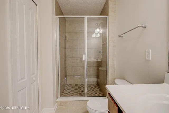 a bathroom with a shower a toilet and sink