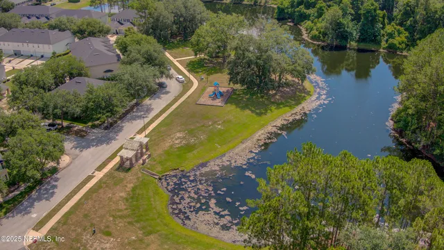 a view of a swimming pool with a yard and large trees