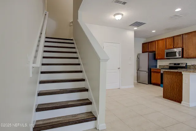 a view of kitchen with sink and refrigerator