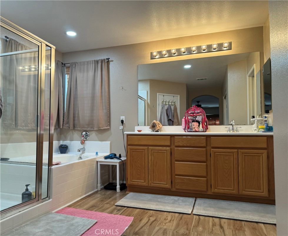 37041 Populus Avenue Palmdale, CA 93552 - Photo 22 of 30 a spacious bathroom with a sink a vanity and a large mirror